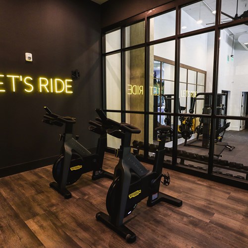fitness center spin room with glass window wall and neon sign